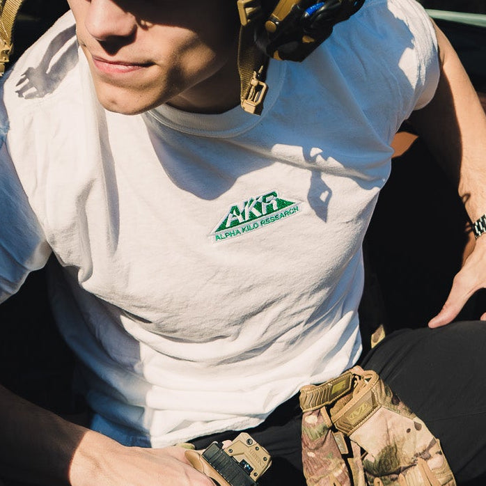 Person in tactical gear sitting in a vehicle with a forest background